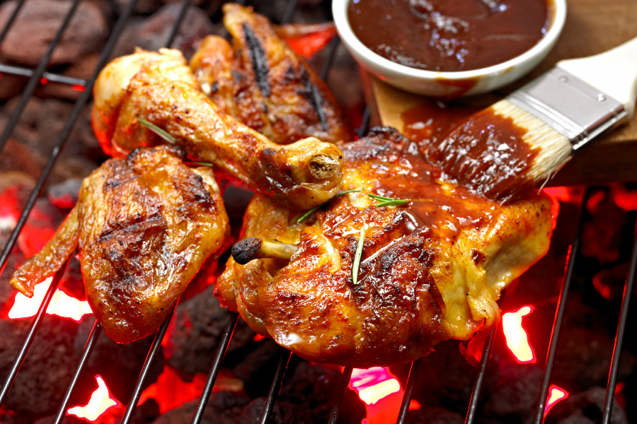 BBQ chicken on the grill with bbq sauce